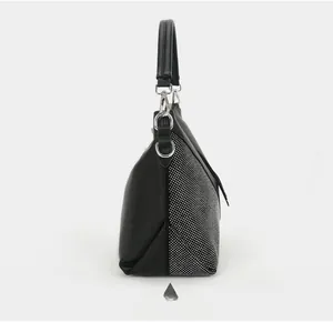 Detail view of the black leather handbag side with glittering rhinestone embellishments