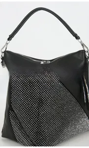 Detail of black litchi leather bag showing geometric silver rhinestone embellishments