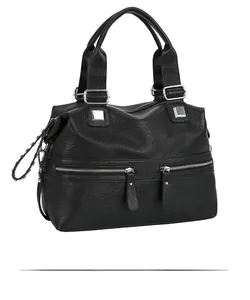 Detailed side view of black faux leather tote bag with silver zippers and chain accents