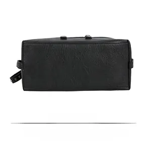 Detailed bottom view of large black tote bag showing soft lychee texture and rivets