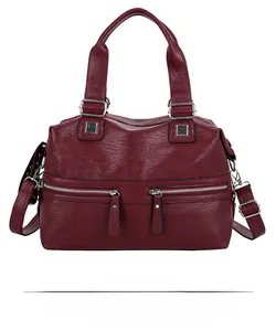 Front detail of red lychee grain leather tote with double zip pockets and silver buckles