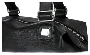 Close-up of premium silver hardware buckle and polished zipper on black leather tote bag