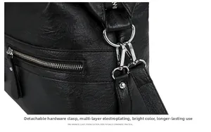 Macro detail of silver-tone metal lobster clasp and hardware on a black leather tote bag