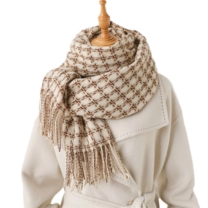 Écharpe d'hiver à motif pied-de-poule avec longues franges sur un manteau crème