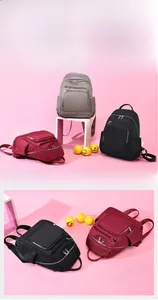 Vue détaillée de sacs à dos en nylon imperméable gris, bordeaux et noir avec zips métalliques