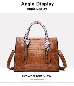 Detail of brown crocodile pattern handbag featuring decorative silk scarf and shoulder strap