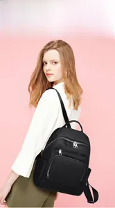 Détail d'un sac à dos en nylon noir avec poches multiples et fermetures éclair métalliques