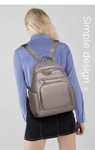 Sac à dos en nylon kaki pour femme porté, avec un design simple et des poches zippées