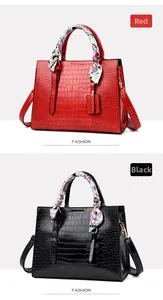 Detail of red and black crocodile embossed handbags with silk scarf wrapped handles