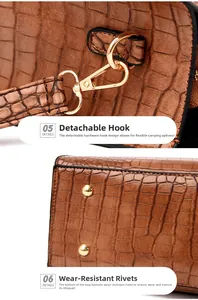 Detail of gold metal hooks and bottom protective studs on brown crocodile texture bag