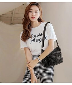 Close-up of black quilted faux leather crossbody bag with multiple zipper compartments
