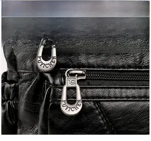 Detailed macro of smooth silver metal zipper and soft litchi grain black leather on handbag