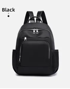 Vue de face du sac à dos en nylon noir imperméable avec fermetures éclair argentées et poches