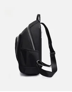 Vue latérale du sac à dos en nylon noir imperméable avec poignée en cuir et zips métal