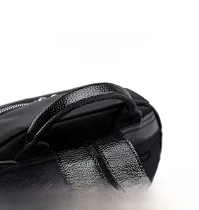 Gros plan de la poignée de sac à dos noire renforcée en cuir de litchi et nylon