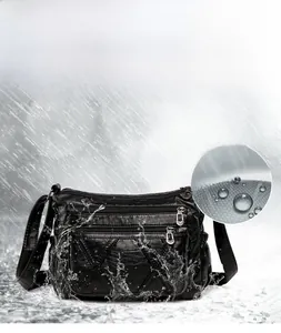 Close-up of waterproof soft PU leather texture on black multi-zipper crossbody bag
