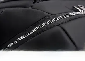 Détail d'une fermeture éclair en métal argenté sur un sac à dos en nylon noir durable