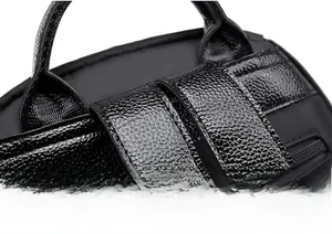Détails macro des doubles coutures précises et du cuir grainé noir sur la sangle du sac à dos