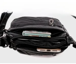 Close-up of black quilted PU leather crossbody bag featuring multi-zipper large capacity