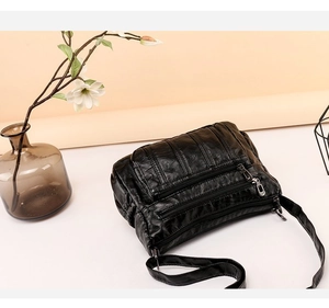 Detail view of multi-layer soft black PU leather crossbody bag with zipper pockets