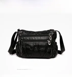 Close-up of black multi-zippered crossbody bag made from vintage soft synthetic leather