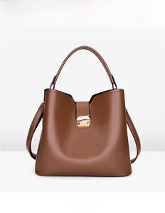 Vue de face d'un sac seau en similicuir marron avec un fermoir métallique doré