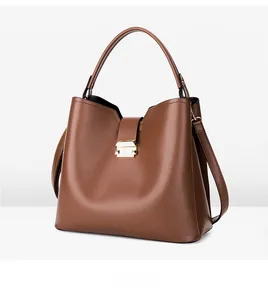 Vue oblique d'un sac seau marron avec boucle en métal doré et texture de cuir finie
