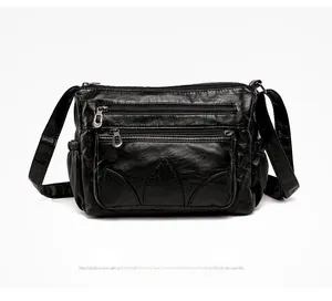 Detail view of black soft PU leather handbag featuring multiple zipper pockets and silver hardware