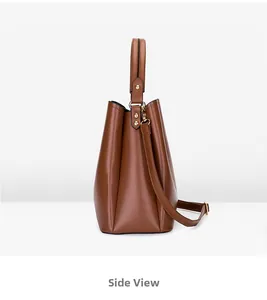 Vue latérale du sac seau marron caramel montrant la texture cuir et rivets dorés