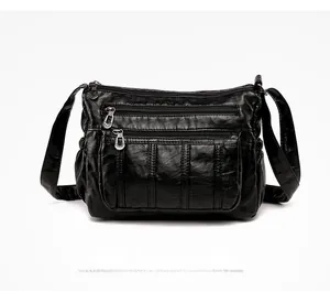 Detail of black soft PU leather shoulder bag with multi-layer zipper pockets and texture