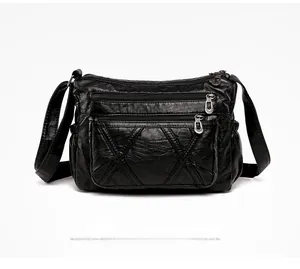 Close-up of black PU leather crossbody bag featuring multiple zippers and quilted diamond patterns