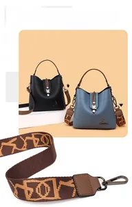 Detail of soft leather bucket bags with dual straps in black and mist blue colors