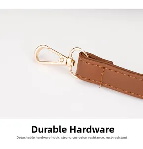 Détail du fermoir mousqueton doré robuste sur bandoulière en cuir marron
