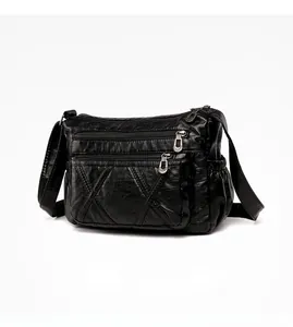 Detail view of the black soft leather crossbody bag with multiple zipper pockets