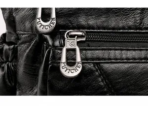 Macro shot of smooth metal zipper detail on black lychee grain faux leather bag