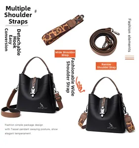 Detail view of black leather bucket bag with two interchangeable style shoulder straps