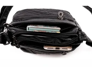 Macro view of multi-layer interior and zipper compartments in black PU leather bag