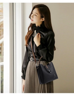 Detail of black pebbled leather bucket bag with leopard strap and gold kangaroo logo