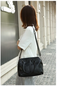 Close-up of black lychee texture tote bag with V-shaped stitching and removable strap