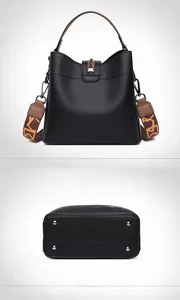 Detailed bottom view of black leather bucket bag showing metal studs and embossed texture