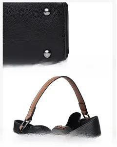 Detail of black pebbled leather bucket bag bottom with metal studs and wide handles