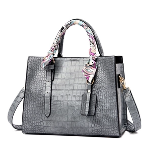 Gray crocodile embossed leather handbag with decorative silk scarf and detachable strap