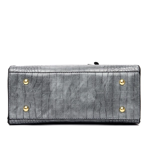 Bottom view of crocodile pattern leather shoulder bag with gold protective feet studs