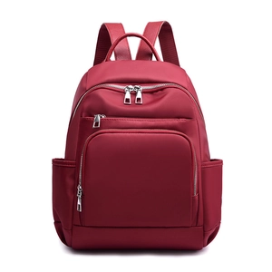 Vue de face d'un sac à dos en nylon bordeaux imperméable avec plusieurs fermetures