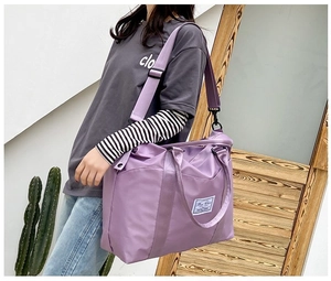 Close-up of purple nylon travel bag featuring wide adjustable shoulder straps and top handles