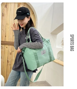 Detailed side view of mint green large sports bag with adjustable strap on a model