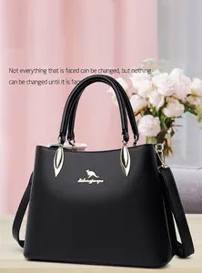 Close-up of black leather handbag featuring gold kangaroo logo and decorative metal hardware