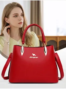 Detail of red leather handbag showing grainy texture and gold kangaroo emblem