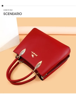 Détail du sac à main en cuir rouge foncé avec logo kangourou doré et boucle en métal