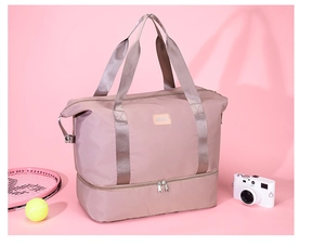 Detalle de bolsa de viaje rosa con tela de nailon impermeable y compartimento para zapatos